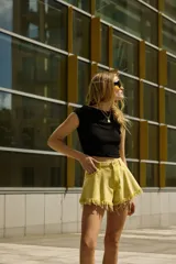 Top corto negro de punto acanalado, corte ajustado, con mangas cortas y escote bote.