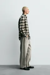 Camisa de corte relaxed fit confeccionada en una mezcla de lana y algodón. Presenta un diseño de cuadros, cuello solapa, manga larga con puños abotonados y cierre frontal con botones.