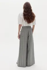 Camisa blanca de algodón con cuello mao, botonera oculta, mangas cortas estilo raglán con cortes estructurados y un bolsillo frontal con cierre.