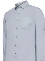 Camisa de manga larga RKF modelo Galiton, color celeste, confeccionada en algodón orgánico. Cuenta con cuello camisero, botones de madera y un bolsillo frontal en el pecho.