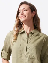 Camisa color verde oliva de lyocell, marca Cyrus. Tiene cuello con solapa, abertura central con botones, mangas 3/4 regulables con presilla y botón, y dos bolsillos delanteros aplicados.