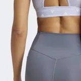 Calza de entrenamiento Adidas de tiro alto, confeccionada en tejido elástico con tecnología AEROREADY. Presenta un diseño ceñido con costuras selladas, cintura elástica de ajuste seguro y un bolsillo oculto en el muslo.