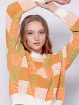 Sweater de tejido de punto con diseño jaquard a cuadros en tonos rosa y verde. Es de manga larga y cuello a la base.