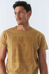 Remera color ocre con estampado cuadrado con las ciudades de Berlin, New York, Dubai, Paris y Shanghai.