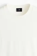 Remera de punto fino color blanco, con cuello redondo acanalado y mangas cortas, de corte slim fit.