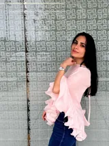 Blusa color rosa pálido de gasa con volados en las mangas y en el ruedo.