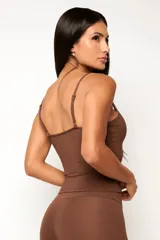 Conjunto deportivo compuesto por una musculosa de breteles finos y una calza de tiro alto, color marrón.