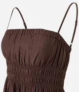 Vestido midi de viscosa certificada, color marrón oscuro, con escote recto y breteles finos. Presenta un canesú fruncido con efecto smock o lastex en el busto y falda de corte amplio.