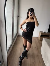 Vestido corto tipo strapless de efecto cuero negro, con detalle de puntilla en el ruedo.