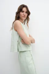 Falda midi verde manzana de lino, con corte recto, cintura alta y tajo lateral.