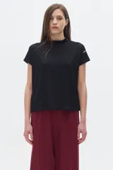 Blusa negra de rib con cuello subido y mangas cortas.