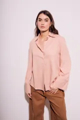 Camisa color salmón de corte oversize, confeccionada en lino y viscosa, con cuello clásico, cierre frontal con botones y mangas largas con puños anchos.