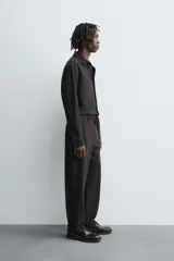 Pantalón de corte relaxed fit, con cintura ajustable, bolsillos delanteros y bolsillo trasero de plastrón. Presenta cierre frontal con cremallera y botón.