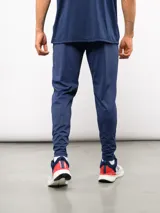 Pantalón de entrenamiento Umbro del Club Nacional de Football, color azul marino. Presenta un diseño técnico con paneles reforzados en la zona de las rodillas, escudo del club en el muslo derecho y logo de la marca en el izquierdo.