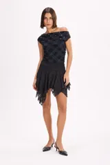 Falda corta asimétrica color negro, confeccionada en tela liviana con diseño en capas y bordes de encaje.