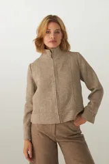 Campera de lana fina con diseño de espiga, cuello alto y cierre frontal completo. Presenta detalles de pespuntes en puños, ruedo y cuello, con un corte estructurado y elegante.