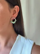 Aro tipo argolla plateado, con cuentas de vidrio facetadas colgantes en tonos verde menta y transparentes/plateados.