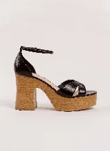 Sandalias de cuero color negro, con plataforma y taco alto grueso con acabado simil madera. Tiras cruzadas en el empeine y tira fina con hebilla al tobillo.