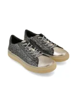 Sneaker de estilo urbano confeccionado en cueros mixtos con acabado de glitter negro en los laterales, puntera metalizada y suela de goma en tono miel. Presenta cordones con hilo de lurex.