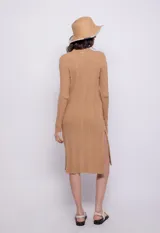 Cárdigan largo de tejido de punto color negro, con siete botones frontales y aberturas laterales.