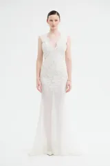 Vestido largo de tul con bordados florales al tono, escote en V profundo y diseño ajustado en el torso con falda fluida.