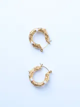 Par de aros dorados tipo argolla con textura y apliques de perlas.