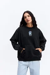 Buzo de algodón con efecto acid wash y diseño vintage. Presenta cuello redondo, mangas largas con puños acanalados, bolsillo frontal tipo canguro y estampa gráfica pequeña en el pecho.