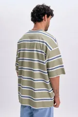 Remera de manga corta con diseño de rayas horizontales en tonos verde, blanco y azul, de corte oversize y cuello redondo en color gris.