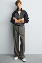 Cazadora relaxed fit en color block, con cuerpo gris oscuro y mangas azul marino. Presenta cuello subido, manga larga, bolsillos frontales de vivo, vivos combinados a contraste en blanco, acabados con rib elástico y cierre frontal con cremallera.