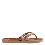 Sandalias tipo ojota Havaianas con base en tonos beige y marrón con diseño de rayas diagonales, y tiras finas metálicas en color cobre.