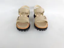 Sandalias bajas color beige con tiras anchas de cuero, ajuste con hebilla y suela track color negro.