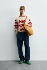 Camiseta de manga larga con cuello redondo, cuerpo color beige claro y mangas a rayas horizontales rojas y beige. Presenta texto frontal en relieve color rojo que dice "WAY MORE ART".