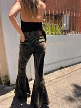 Jeans de denim negro con efecto acid wash, corte wide leg y dobladillos con flecos.