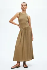 Vestido midi verde militar sin mangas, con cuello redondo y costura fruncida en diagonal bajo la cintura. Cuerpo entallado en punto acanalado de algodón y falda con vuelo.
