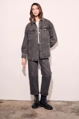 Jean de tiro alto, corte recto y largo al tobillo, en color negro lavado con apliques de strass o brillos distribuidos por toda la prenda.