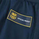 Short de fútbol azul con cordón de ajuste en la cintura, escudo del FC Barcelona en la pierna derecha y la palabra "Barça" en la pierna izquierda.