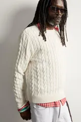 Sweater de punto verde con diseño de trenzas, cuello redondo y manga larga, de corte regular fit y acabados en rib.