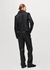 Chaqueta estilo aviador de color negro con interior de piel sintética gris oscuro, cierre frontal cruzado con cremallera y solapas grandes.