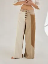 Pantalon ancho de denim en varios tonos de azul con diseño patchwork, de tiro medio y cierre frontal con botones.