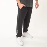 Pantalón de jogging negro de corte oversize, confeccionado en algodón con felpa interior. Presenta bordado con la frase 'JUST BEGIN' en la parte inferior de la pierna derecha y detalle bordado en la pierna izquierda.