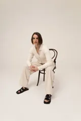 Camisa color crudo de punto 100% algodón, con cuello polo, manga larga y cierre frontal con botones.