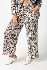 Pantalón palazzo beige con estampado animal print, cintura elástica y corte amplio.