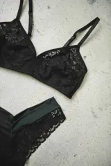 Soutien negro confeccionado en encaje con diseño floral, tirantes finos regulables y cierre posterior.