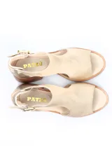 Sandalia de cuero negro con taco bloque efecto madera, puntera abierta y tira ajustable al tobillo con hebilla metálica dorada.