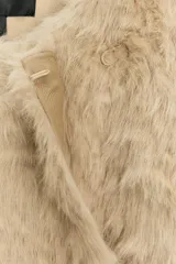 Abrigo de Zara Woman Collection con textura efecto pelo, cuello redondo y manga larga. Presenta un diseño cruzado con cinturón ajustable del mismo tejido y bolsillos delanteros.