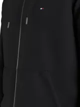 Buzo negro con capucha, cierre de cremallera, bolsillos laterales y logo de Tommy Hilfiger bordado en el pecho.