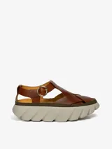 Sandalias de cuero color marrón con tiras entrecruzadas, cierre de hebilla y plataforma de goma.