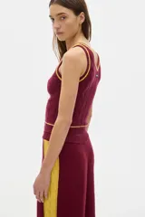 Musculosa tejida color borgoña con cuello en V y ribete amarillo.