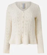 Cardigan de punto color crema con cuello en V, cierre frontal con botones y detalle de volado en el ruedo. Presenta mangas largas y un diseño texturizado con calados verticales.
