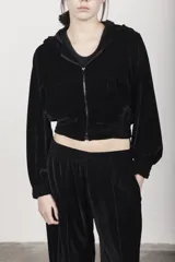 Campera negra de terciopelo con capucha doble, cierre frontal, dos bolsillos y frunce en puños y cintura.